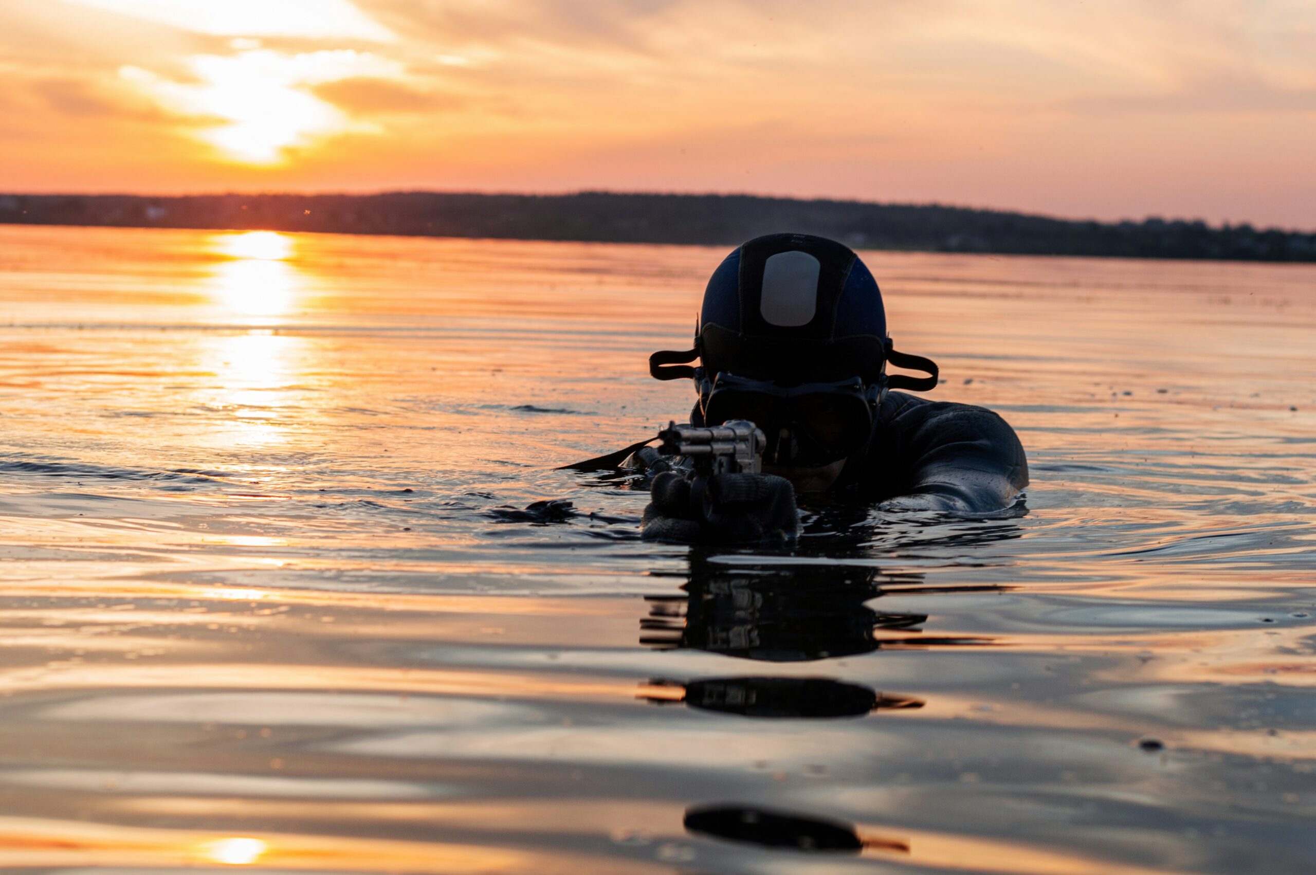 Scuba diver emerges from water holding weapenry