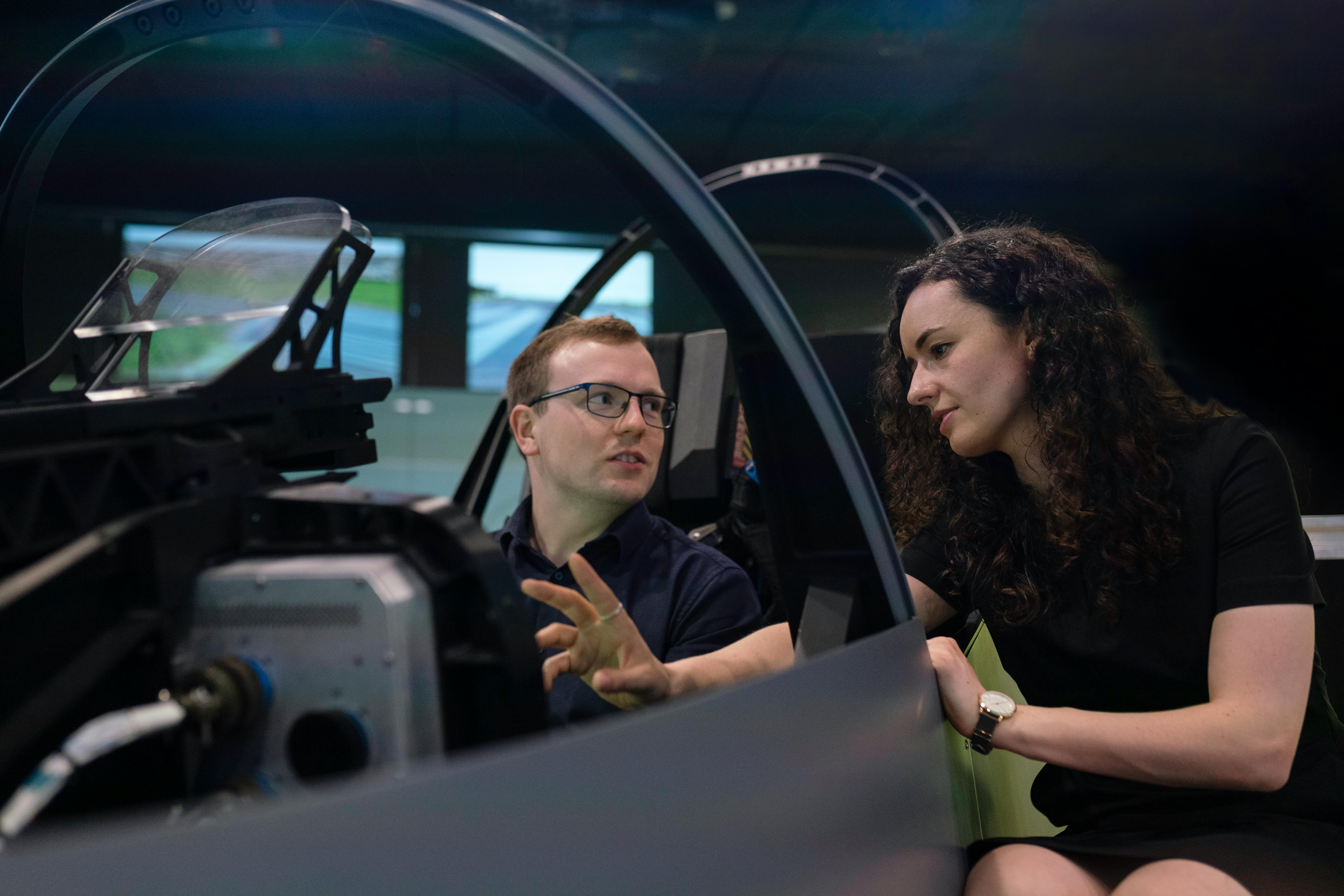 two engineers discussing specs in a car simulator